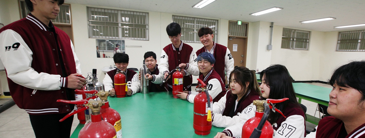 여러개의 소화기를 앞에두고 모여있는 학생들 사진